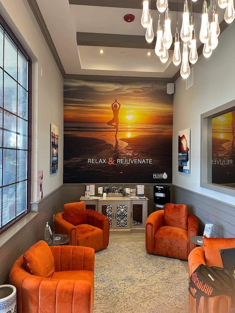 Prime IV Hydration & Wellness Blue Bell relaxation lounge with orange chairs and Relax & Rejuvenate mural